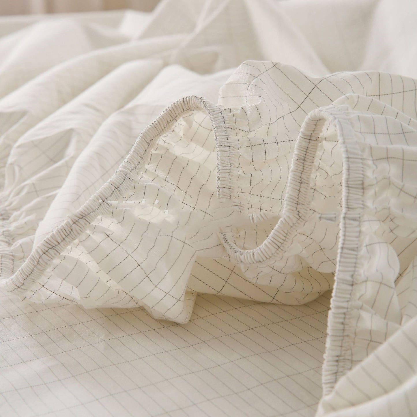 Close-up of a textured white fabric with grid pattern on a light background